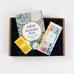 A gift activity package for adults, containing a coloring and creativity kit, including a coloring book, colored pencils, and vegan chocolate bar presented in a box and a