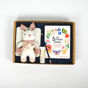 A gift package for new mums containing a plush toy, a journal, and a tube of hand cream, all presented in a decorative gift box with a blue interior.