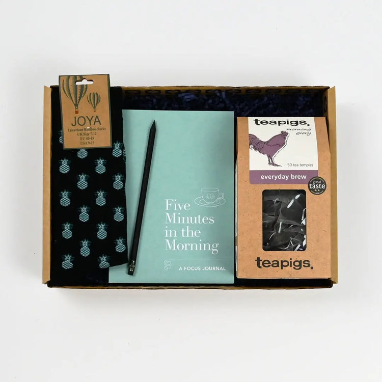 Men's Stress Relief Gifts Package containing a five minutes in the morning journal, a pencil, teapigs everyday tea, and some wool socks with pineapple design
